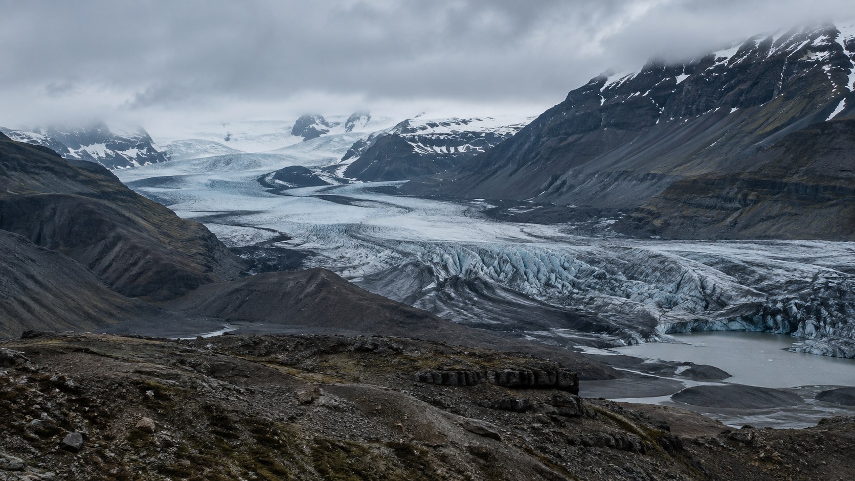 Blaugrauer Gletscher zwischen dunklen Felslinien